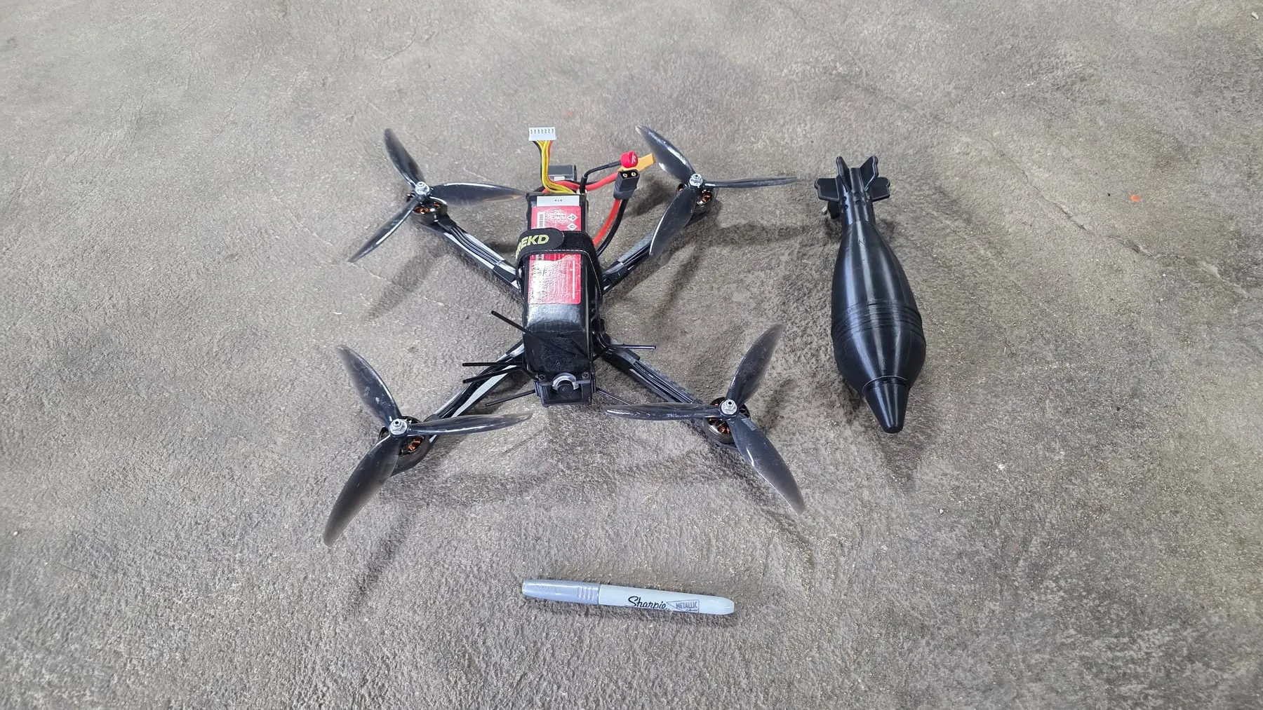 A purpose-built representative-threat FPV platform with a payload.